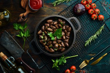 Maydanozlu kızarmış tavuk kalbi ve metal bir tavada baharat. Üst Manzara. Metin için boş alan.