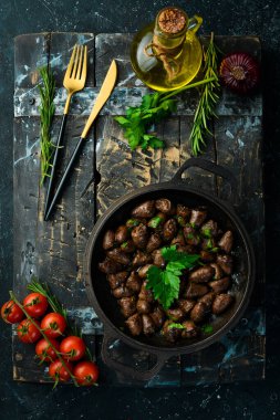 Maydanozlu kızarmış tavuk kalbi ve metal bir tavada baharat. Üst Manzara. Metin için boş alan.