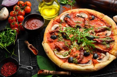 Güneşte kurutulmuş domatesli, mantarlı ve zeytinli ev yapımı pizza. İtalyan mutfağı. Yemek teslimatı.
