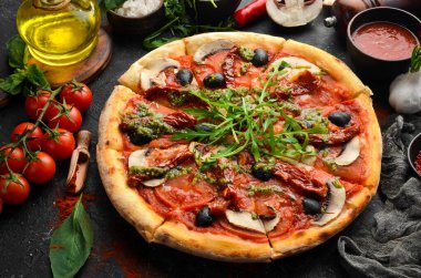 Güneşte kurutulmuş domatesli, mantarlı ve zeytinli ev yapımı pizza. İtalyan mutfağı. Yemek teslimatı.