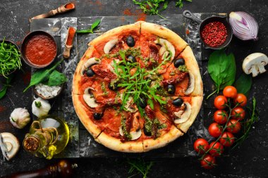Güneşte kurutulmuş domatesli, mantarlı ve zeytinli ev yapımı pizza. İtalyan mutfağı. Yemek teslimatı.