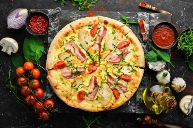Tavuklu pizza, pastırma ve vişneli domates. İtalyan mutfağı. Siyah bir arkaplanda.