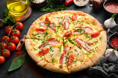 Tavuklu pizza, pastırma ve vişneli domates. İtalyan mutfağı. Siyah bir arkaplanda.