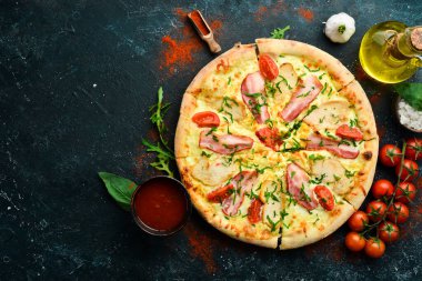 Tavuklu pizza, pastırma ve vişneli domates. İtalyan mutfağı. Siyah bir arkaplanda.