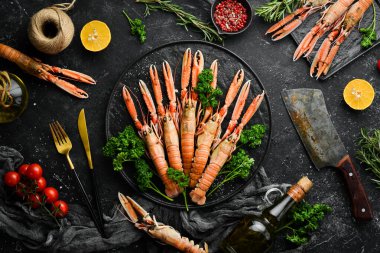 Siyah taş tabakta maydanozlu ve baharatlı haşlanmış Scampi. Siyah taştan bir arka planda Norveç ıstakozu. Üst Manzara. Boş kopyalama alanı.