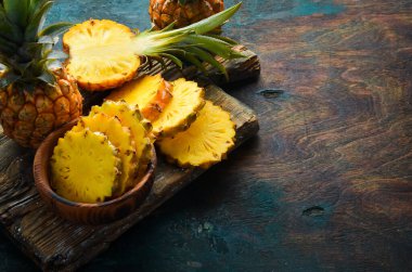 Siyah bir arka planda dilimlenmiş olgun bebek ananası. Tropik meyveler. Üst Manzara. Metin için boş alan.