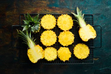 Siyah bir arka planda dilimlenmiş olgun bebek ananası. Tropik meyveler. Üst Manzara. Metin için boş alan.