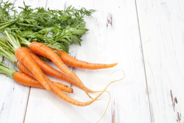 ahşap masa üzerinde genç havuç demet