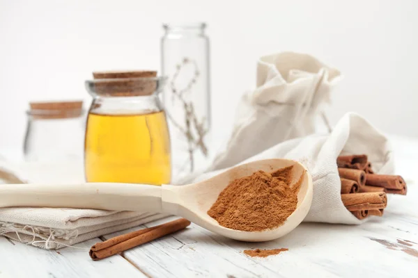 Canela molida, miel y palitos de canela sobre fondo blanco — Foto de Stock