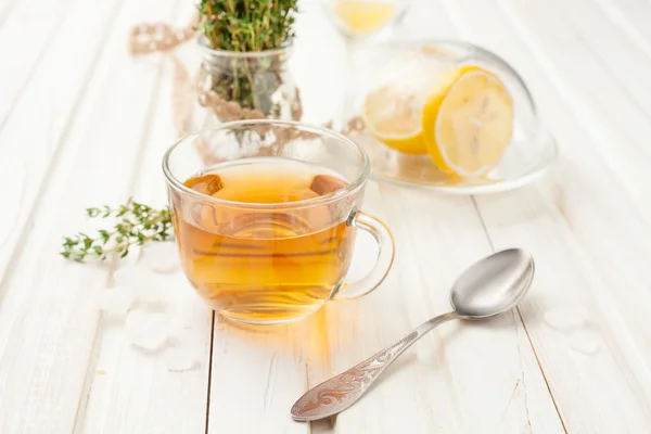Травяной чай в стеклянной чашке с тимьяном на белом — стоковое фото