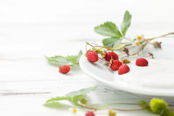 Crema agria con fresas silvestres sobre mesa de madera blanca — Foto de Stock