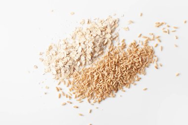 Beyaz arka planda pullar ve soyulmuş yulaf taneleri. Boşluk metnini kopyala.