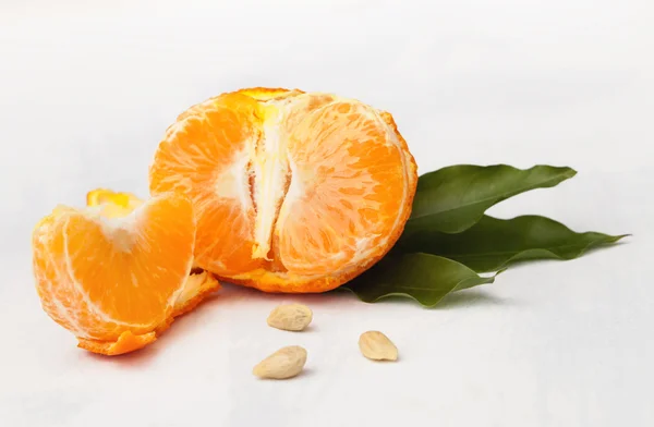 Mandarino spezzato con semi su sfondo bianco — Foto Stock