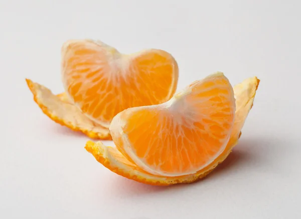 Le fette di mandarino con pelli su sfondo bianco — Foto Stock