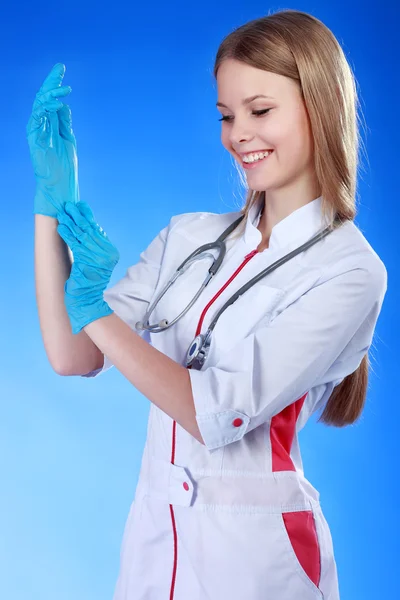 Porträtt av ung kvinna läkare med vit rock och blå handskar — Stockfoto
