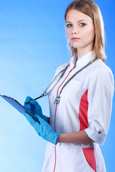 Médico sonriente con una carpeta en uniforme de pie en hospi —  Fotos de Stock