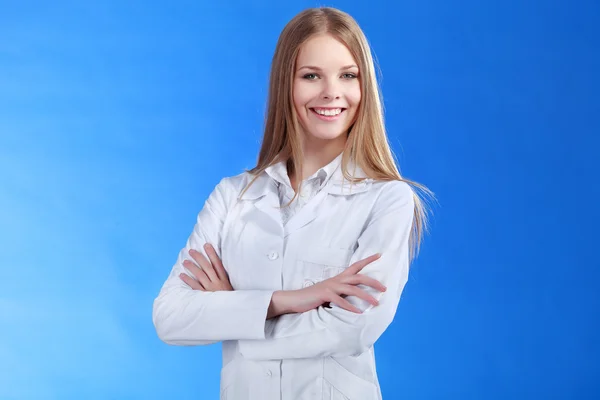 Joven médico atractivo aislado sobre fondo azul —  Fotos de Stock