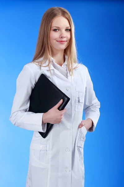 Joven atractivo médico femenino está de pie con el portapapeles un —  Fotos de Stock