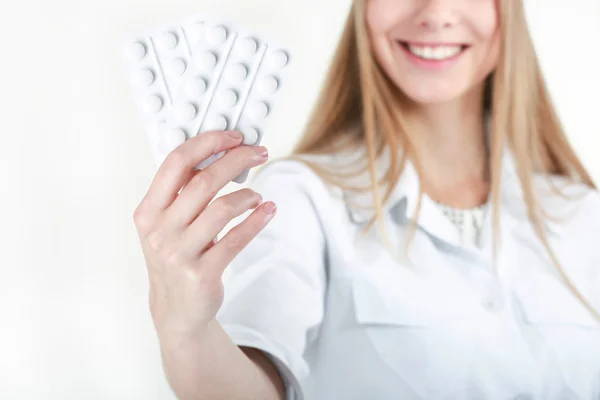 En vacker ung sjuksköterska erbjuder piller — Stockfoto