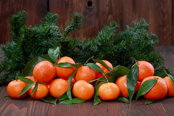 Tangerines avec feuilles sur la surface en bois — Photo