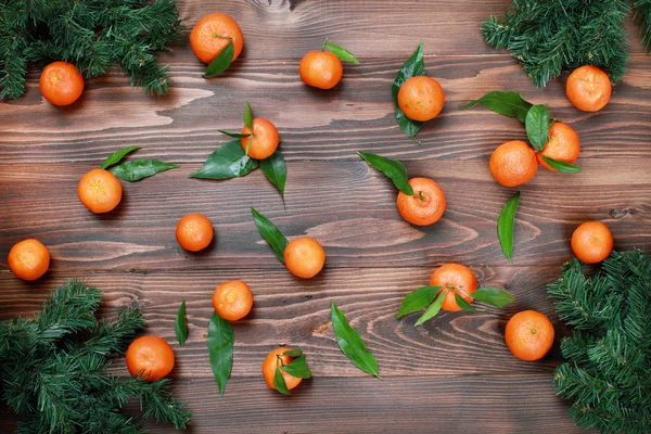 Mandarinen mit Blättern auf Holzoberfläche — Stockfoto