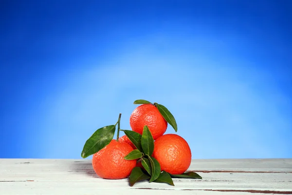 Tangerines avec feuilles sur la surface en bois — Photo