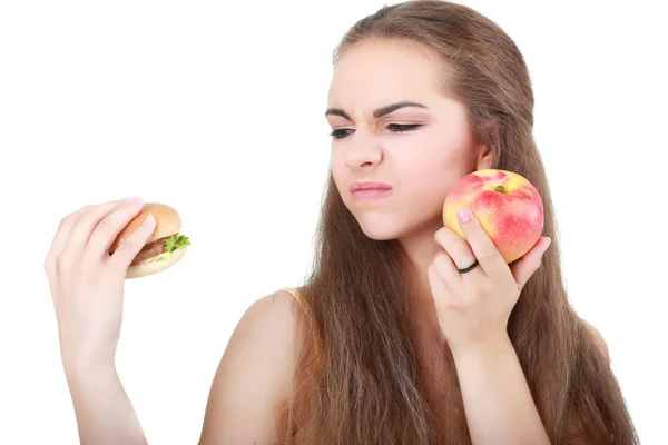 Vrouw overgaat tussen gezonde voeding en fast food — Stockfoto