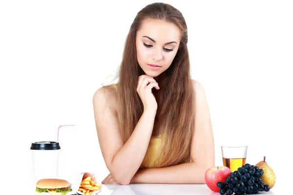 Twijfelende meisje met apple en hamburger geïsoleerd — Stockfoto