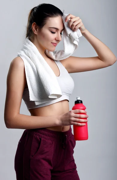 Junge gesunde Fitness-Frau mit Handtuch und Wasser — Stockfoto