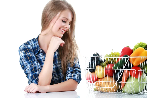 Mujer joven aislada sosteniendo cesta de verduras sobre fondo claro —  Fotos de Stock