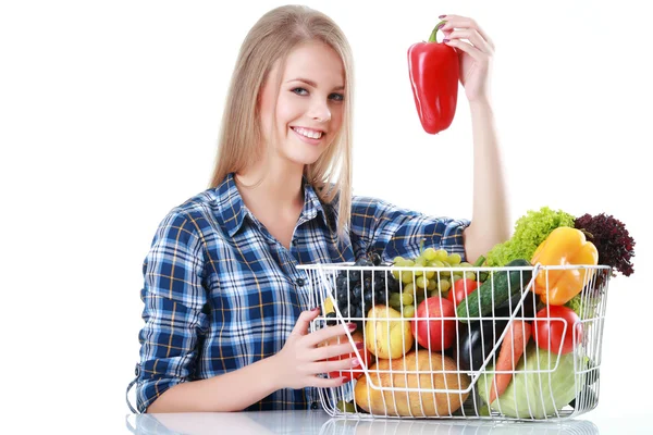 Geïsoleerde jonge vrouw met mand van groenten op lichte backgraund — Stockfoto