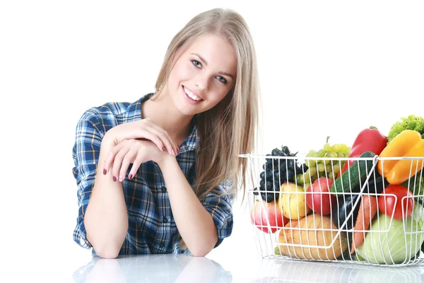 Mujer joven aislada sosteniendo cesta de verduras sobre fondo claro — Foto de Stock