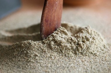 Beyaz arka planda balkabağı tohumlarıyla un içinde ahşap kepçe. Alternatif un.