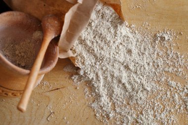 Almond flour pile from top on wooden background clipart