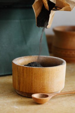 Ahşap masada yemek pişirmek için haşhaş tohumları.