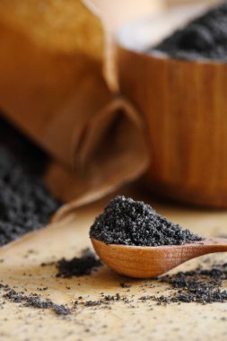 Ahşap masada yemek pişirmek için haşhaş tohumları.