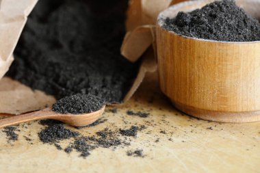 Haşhaş unu ahşap kahverengi bir masaya saçılmış.