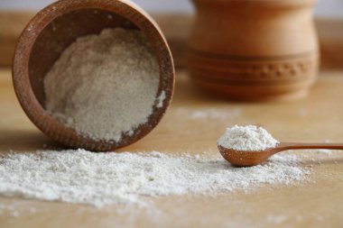 Hindistan cevizi unu bir kâse içinde hindistan cevizi parçaları olan bir kaşık yakın plan