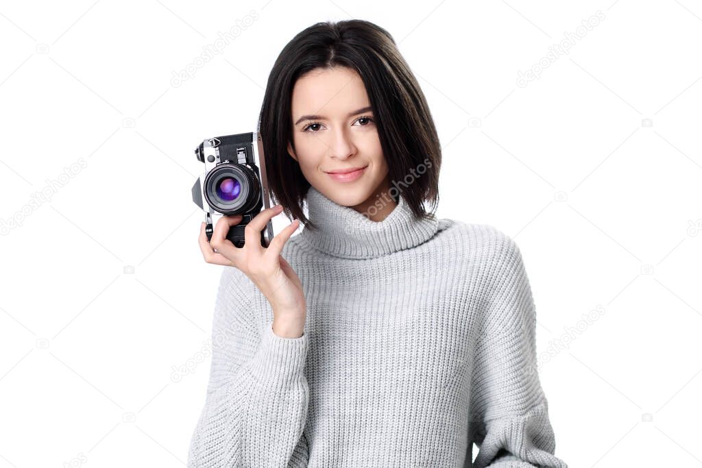 Woman takes images holding photographic camera, isolated on a white