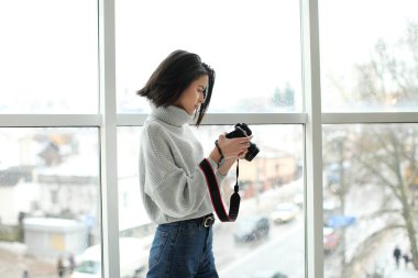 Elinde klasik fotoğraf makinesi olan bir kız.