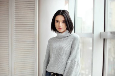 Pencerenin yanında duran bir kadının portresi