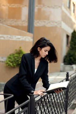 Bir yaz caddesinde bir binanın yakınında ceketli güzel bir genç kız.