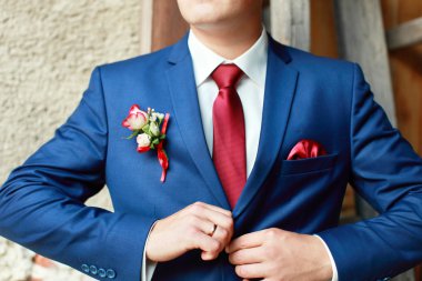 Mavi takım damadın üzerinde yaka çiçeği