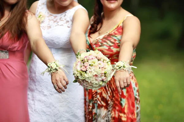 Las manos de la novia y sus amigos y las flores de la boda — Foto de Stock