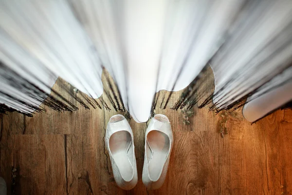 Bride's shoes near the curtains — Stock Photo, Image