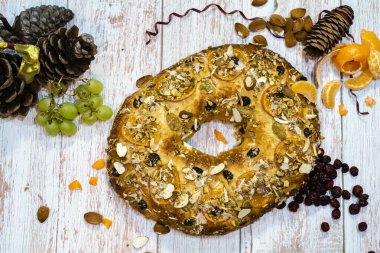 Roscon de Reyes geleneksel İspanyol tatlıları Noel 'de badem kreması ve kırsal arka planda şekerli meyvelerle yapılır.