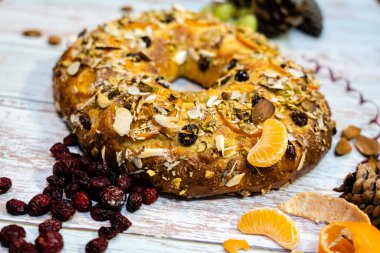 Roscon de Reyes geleneksel İspanyol tatlıları Noel 'de badem kreması ve kırsal arka planda şekerli meyvelerle yapılır.