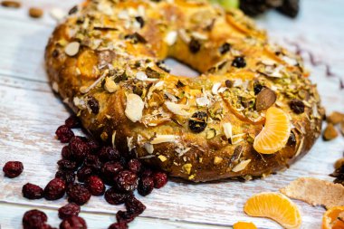 Roscon de Reyes geleneksel İspanyol tatlıları Noel 'de badem kreması ve kırsal arka planda şekerli meyvelerle yapılır.