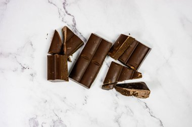 Kaliteli çikolata beyaz mermer tablet üzerinde parçalara ayrıldı.