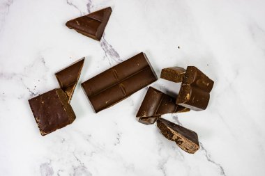Kaliteli çikolata beyaz mermer tablet üzerinde parçalara ayrıldı.